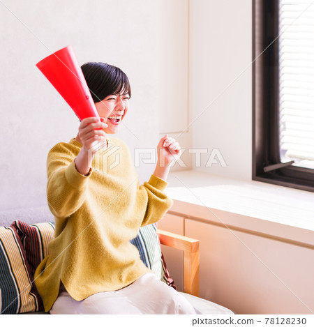 一位年輕女子在電視上看體育節目 [Corona Sorrow New Normal] 78128230