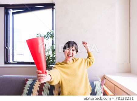 一位年輕女子在電視上看體育節目 [Corona Sorrow New Normal] 78128231