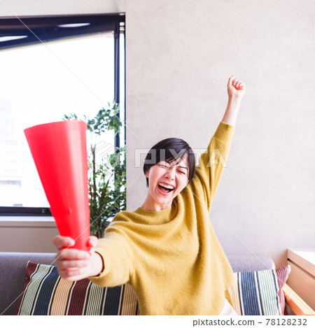 一位年輕女子在電視上看體育節目 [Corona Sorrow New Normal] 78128232