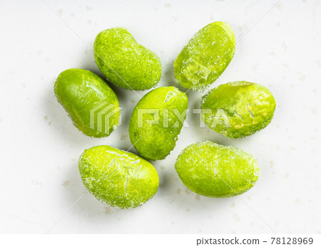 several frozen unripe soybeans close up on gray 78128969