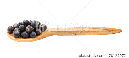 wooden spoon with dried juniper berries isolated 78129072