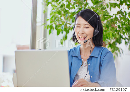 在客廳裡有一個在線會議的中年女人 在客廳裡有一個在線會議的中年女人 78129107