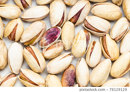 background - many shelled and ripe pistachio nuts 78129129