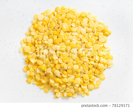 pile of raw split yellow lentils close up on gray 78129171