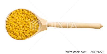 top view of wood spoon with uncooked ptitim pasta 78129225