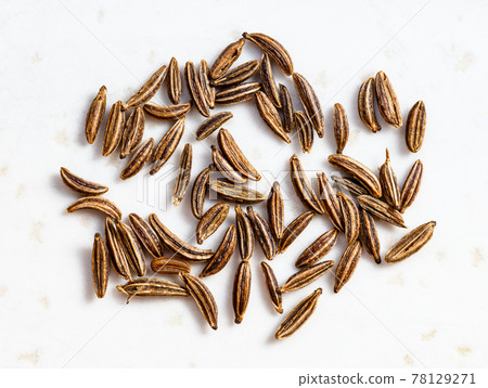 several caraway seeds close up on gray 78129271
