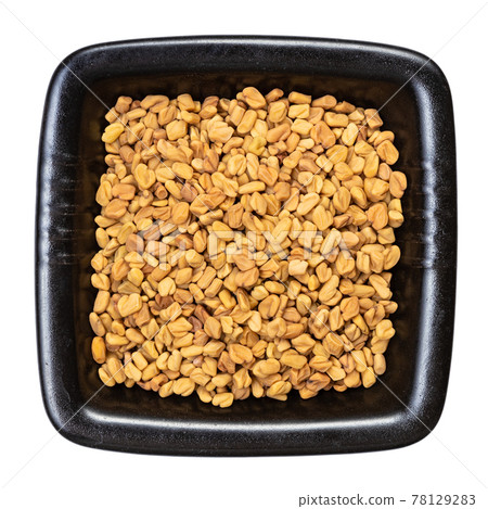 whole fenugreek seeds in black bowl isolated whole fenugreek seeds in black bowl isolated 78129283