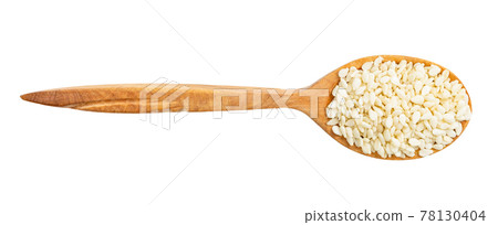 view of wood spoon with raw white sesame seeds 78130404