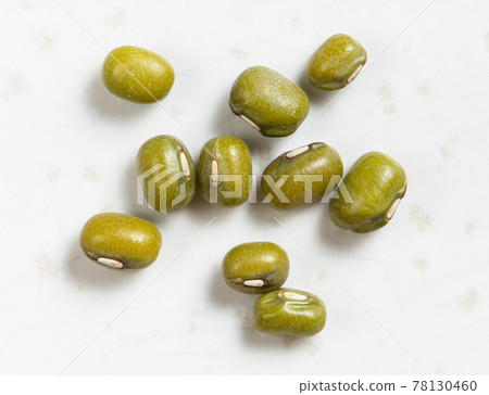 several raw green mung beans close up on gray 78130460