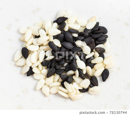 black and white mixed sesame seeds closeup on gray 78130744