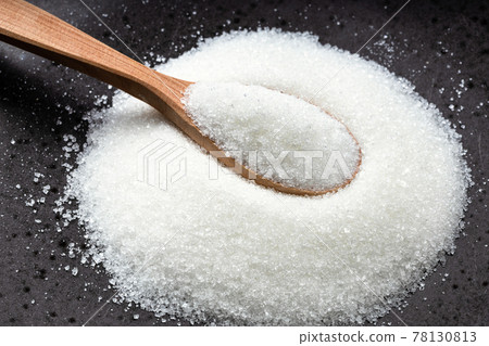 wooden spoon with white refined sugar on black 78130813