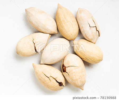 several cracked pecan nuts close up on gray several cracked pecan nuts close up on gray 78130988
