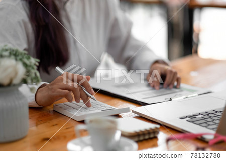 Close up woman using computer calculating finance or taxes on machine, female manage home family expenditures, using calculator, make payment on laptop Close up woman using computer calculating finance or taxes on machine, female manage home family expenditures, using calculator, make payment on laptop 78132780
