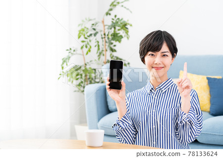 一名年輕女子展示智能手機屏幕。 一名年輕女子展示智能手機屏幕。 78133624