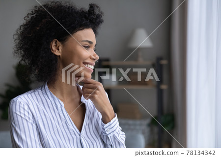 Smiling African American woman look in distance dreaming 78134342