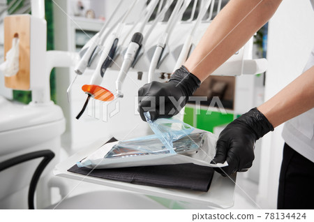 Dentist opening package with sterile dental instruments. Dentist opening package with sterile dental instruments. 78134424