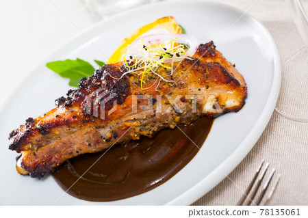Roasted pork ribs in chocolate sauce with baked potatoes 78135061