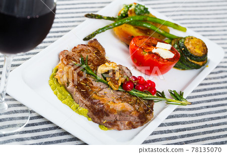 Fried beef loin with avocado puree and vegetables 78135070