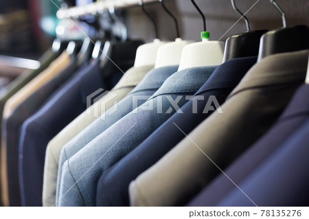 Men suits on hanger racks in shop 78135276