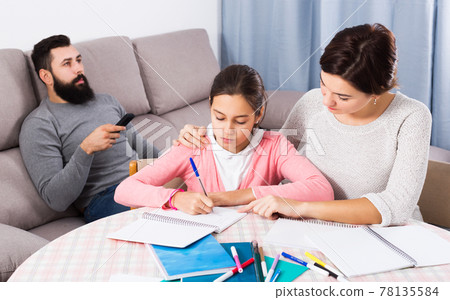 Mother helping child to do homework 78135584