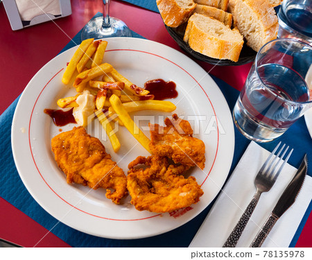 Crisp chicken nuggets with golden brown crust and french fries Crisp chicken nuggets with golden brown crust and french fries 78135978