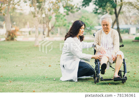 Doctor help and care Asian senior or elderly old lady woman patient sitting on wheelchair at park in nursing hospital ward, healthy strong medical concept. 78136361