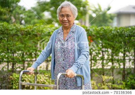 Asian senior or elderly old lady woman use walker with strong health while walking at park in happy holiday 78136366