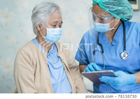 Asian doctor wearing face shield and PPE suit new normal to check patient protect safety infection Covid-19 Coronavirus outbreak at quarantine nursing hospital ward. Asian doctor wearing face shield and PPE suit new normal to check patient protect safety infection Covid-19 Coronavirus outbreak at quarantine nursing hospital ward. 78138730