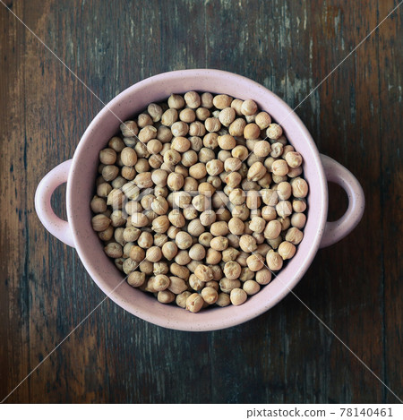Pink plate with chick peas on wooden background - view from above Pink plate with chick peas on wooden background - view from above 78140461