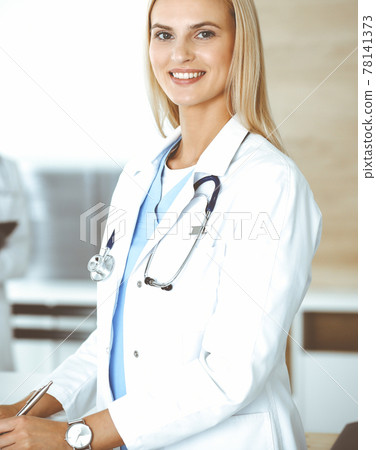 Doctor woman controls medication history records and exam results while using clipboard. Medicine and healthcare concept Doctor woman controls medication history records and exam results while using clipboard. Medicine and healthcare concept 78141373