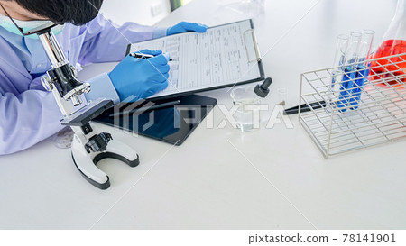 Medical or scientific researcher or man doctor looking at a test tube of clear solution in a laboratory Medical or scientific researcher or man doctor looking at a test tube of clear solution in a laboratory 78141901