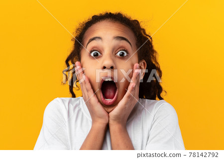 Wow. Excited black girl touching her cheeks 78142792