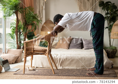 African young man working out, practicing yoga, standing in Ardha Uttanasana African young man working out, practicing yoga, standing in Ardha Uttanasana 78143294
