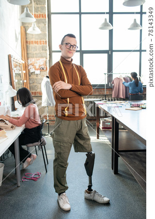 Young disable man in casualwear standing in workshop 78143349