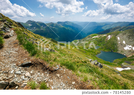 capra lake of fagaras mountains. wonderful summer nature scenery on a sunny day. popular travel destination of romania. snow and grass on the slopes. fluffy clouds on the sky 78145280