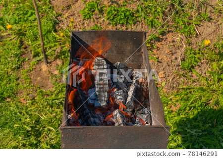 Old rusty brazier is preparing for frying kebabs, lighted charcoal on the grill 78146291