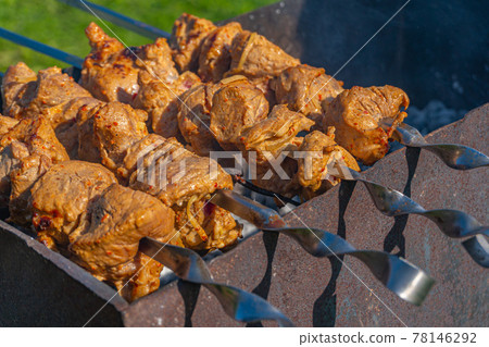 Grilled meat on skewers, fried kebabs on skewers on rusty brazier 78146292
