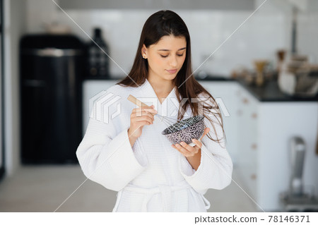 Elegant smiling woman in white coat preparing food Elegant smiling woman in white coat preparing food 78146371