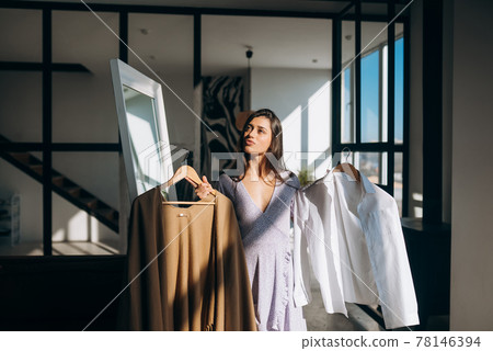 Beautiful girl trying dress in room Beautiful girl trying dress in room 78146394