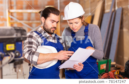 Disgruntled foreman discussing drawing with worker Disgruntled foreman discussing drawing with worker 78147247