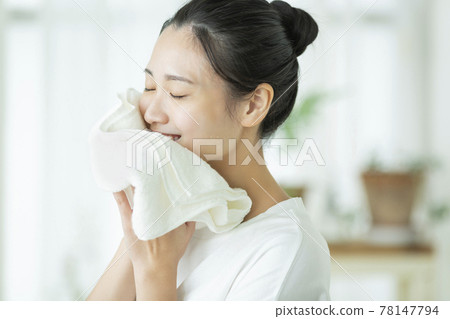 一位年輕的女士用毛巾擦臉 一位年輕的女士用毛巾擦臉 78147794