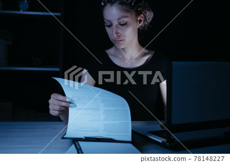 Young focused woman doing overtime job at night 78148227