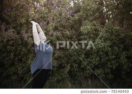 Plus size woman stretching hands relaxing outdoors Plus size woman stretching hands relaxing outdoors 78148450