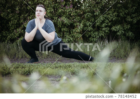 Young overweight woman doing yoga at summer meadow 78148452