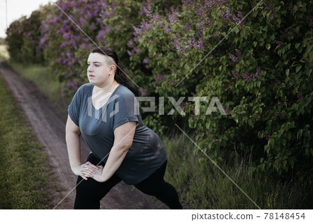 Overweight woman warming up muscles before workout Overweight woman warming up muscles before workout 78148454