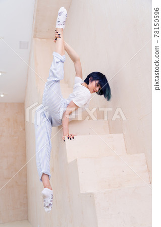 Flexible girl doing stretching and handstand in studio. Concept of individuality, creativity and self-confidence 78150596