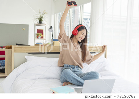 Relax woman holding book read on bed using headphone listen music. Young woman relaxation reading open book leisure mind. Happiness beautiful woman person Relax woman holding book read on bed using headphone listen music. Young woman relaxation reading open book leisure mind. Happiness beautiful woman person 78150762