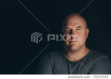bald handsome man in gray clothes on black background bald handsome man in gray clothes on black background 78153355
