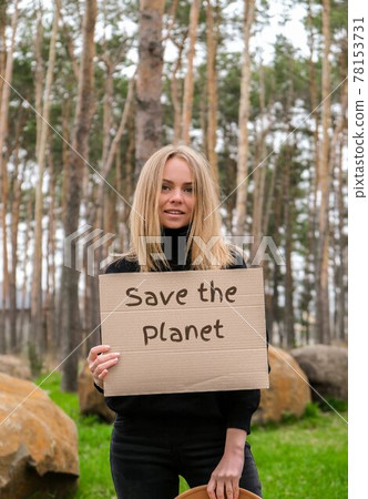 Portrait of caucasian young woman in hat holding cardboard with text SAVE THE PLANET outdoors. Nature background. Protester activist 78153731
