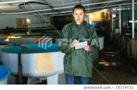Woman checking reservoirs with trout fry 78154532